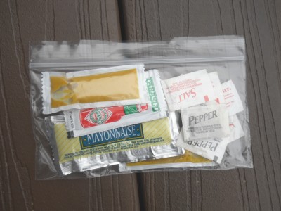 A snack-sized Ziplock bag of disposable condiment packets