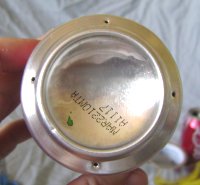 Four evenly-placed holes around the rim of the bottom of a soda can