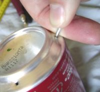 Poking a hole in the rim of the bottom of a soda can