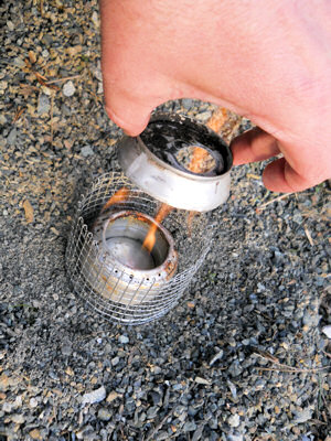 Dropping the simmer ring into place on the soda can stove