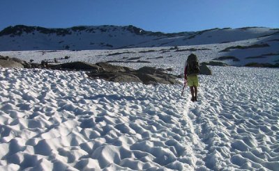 A hiker in snow heading toward Donahue Pass in the High Sierra